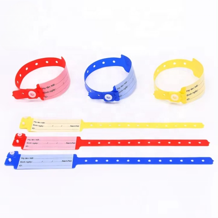 Red, blue and yellow handwritten patient wristbands with writable panels laid out in rows