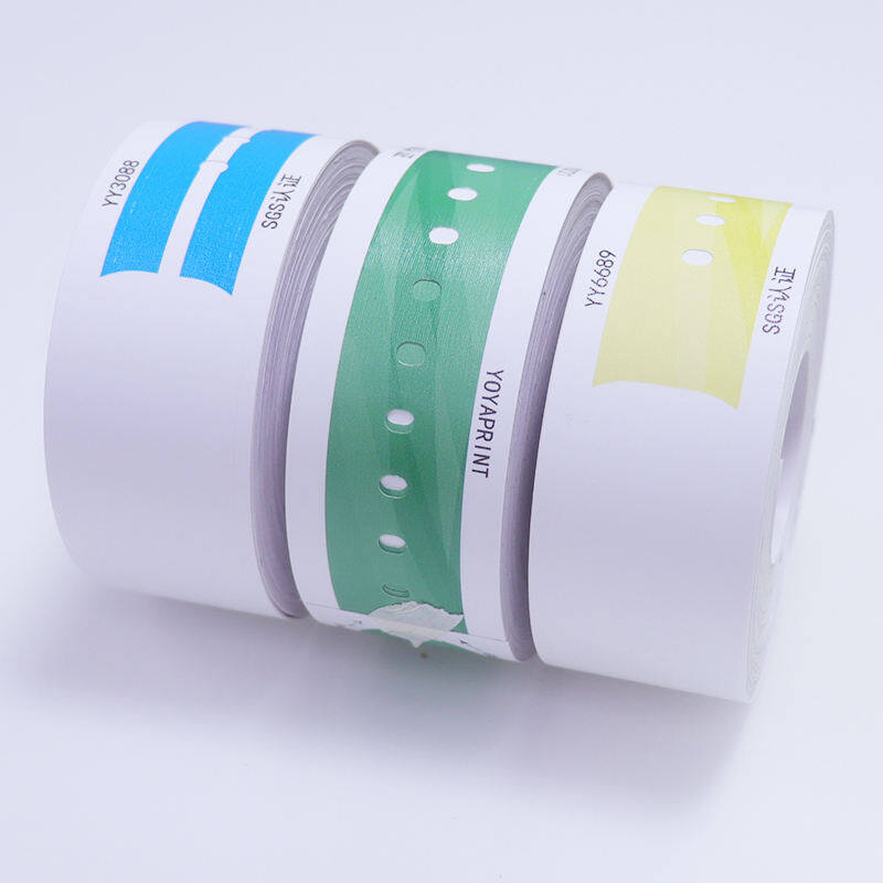 Three rolls of thermal printable hospital wristbands in blue, green, and yellow colors