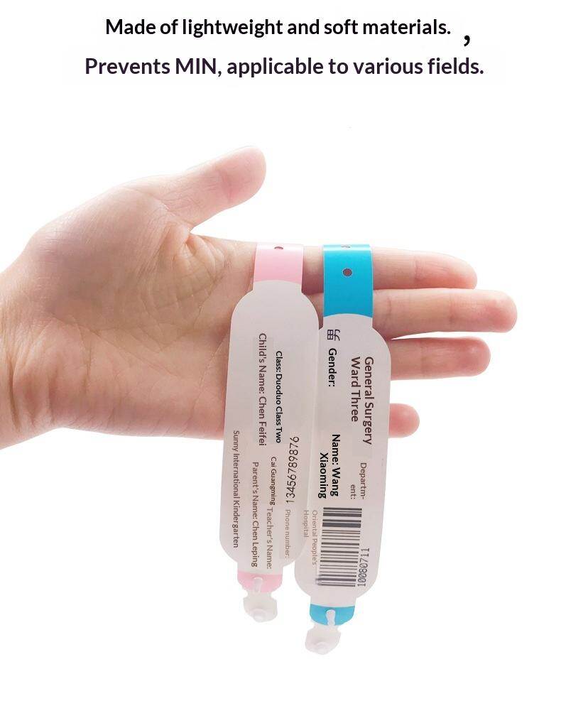 Hand holding small pink and blue wristbands demonstrating size difference for neonatal patients