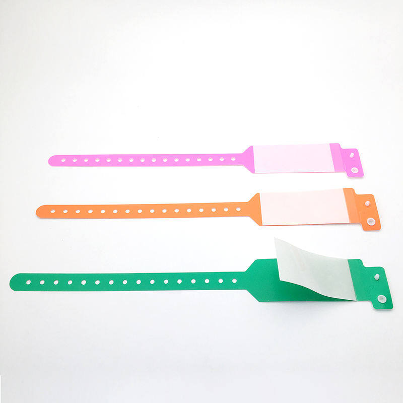 Three colored hospital wristbands in pink, orange, and green with adhesive closure for patient identification