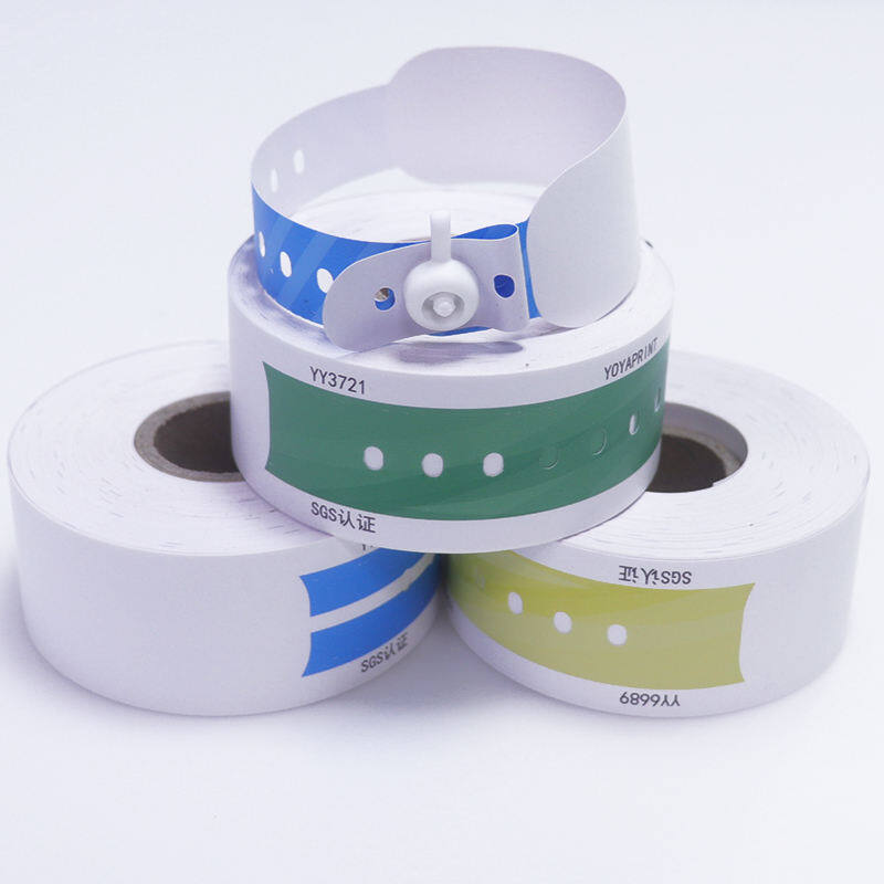 Stacked rolls of hospital wristbands in blue, green, and yellow with snap closure for patient identification