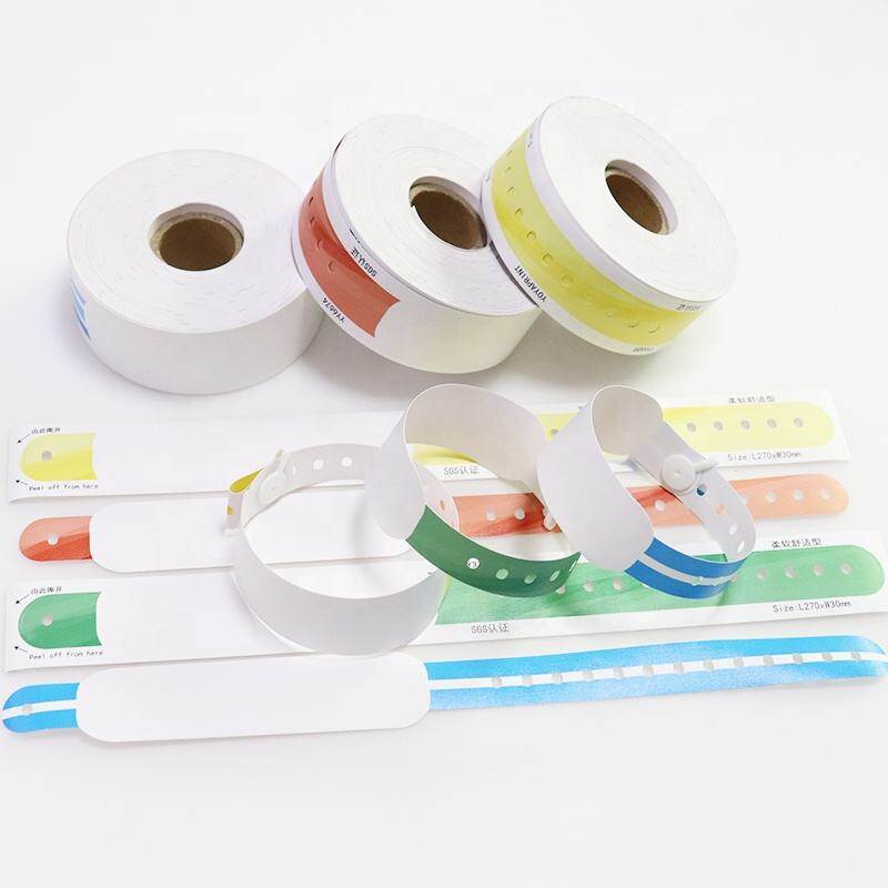 Rolls of medical wristbands with applied looped bands in white, green and blue