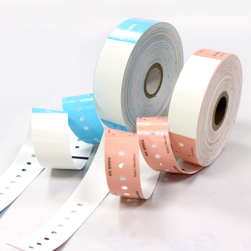 Pink and blue thermal patient wristband rolls unspooled on a white background