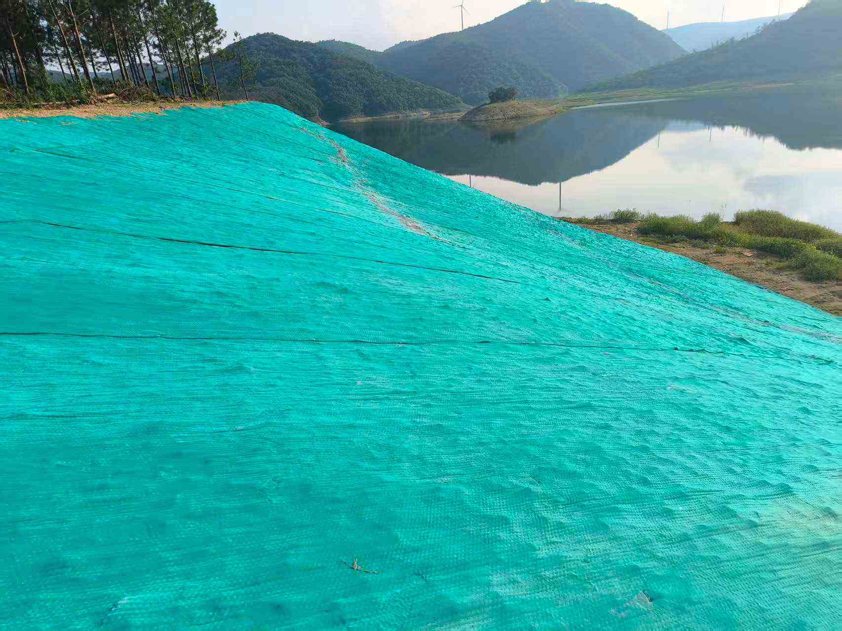 湖北玖坤国标水泥毯湖北水库边坡防渗完工实拍,全覆盖山体坡面隔绝地下水渗漏。