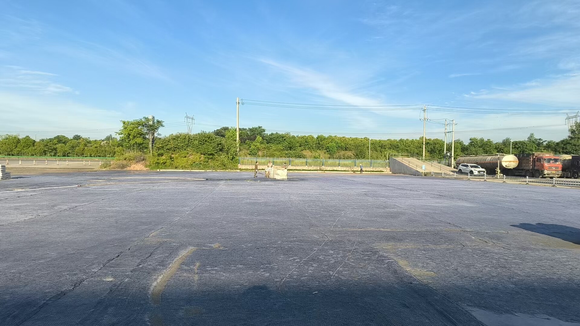湖北玖坤国标 JC/T2884 水泥毯露天堆场地坪施工实拍,大面积平铺固化,重载耐磨防渗厂区硬化。