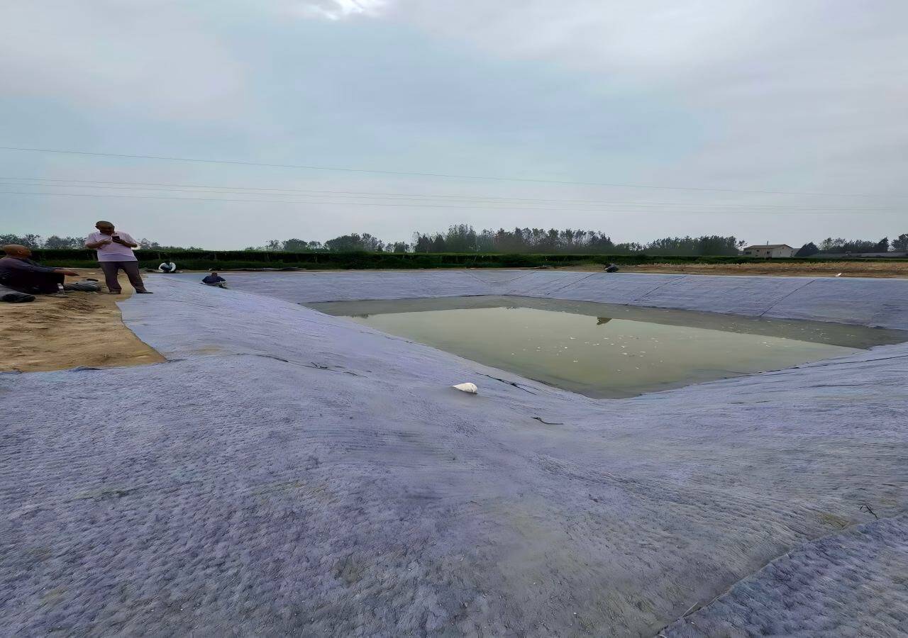 水产养殖蓄水塘水泥毯护坡防渗施工现场,鱼塘池底边坡铺设水泥毯