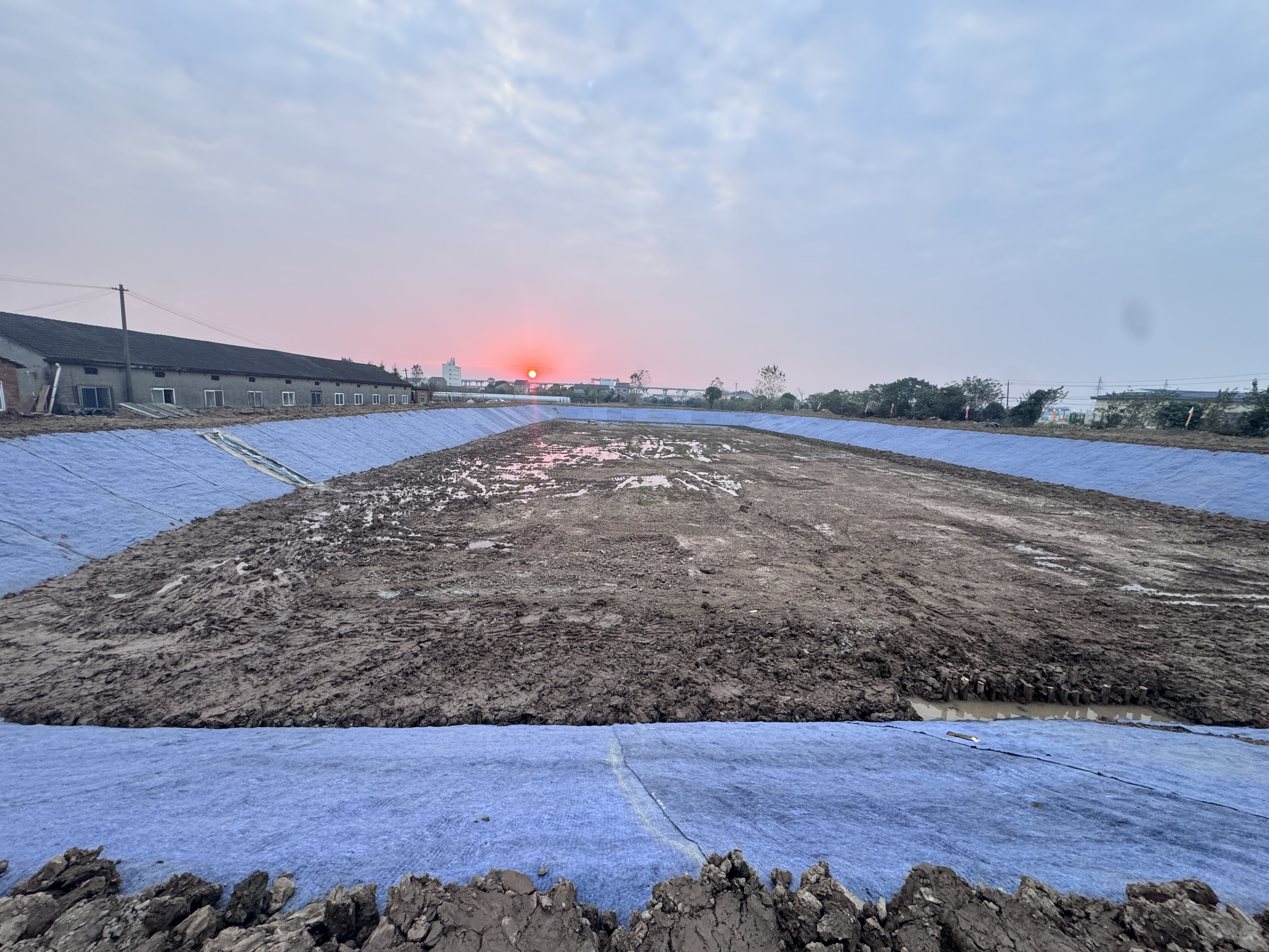 湖北宜昌鱼塘水泥毯护坡防渗施工现场,水产养殖塘边坡铺设水泥毯实景