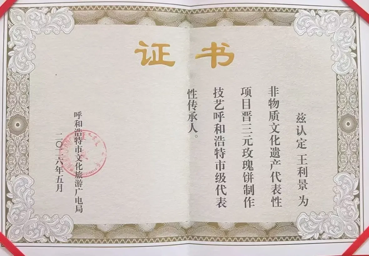 呼和浩特市级非物质文化遗产代表性传承人证书：兹认定王利景为非物质文化遗产代表性项目“晋三元玫瑰饼制作技艺”呼和浩特市级代表性传承人，落款呼和浩特市文化旅游广电局，二〇二六年五月