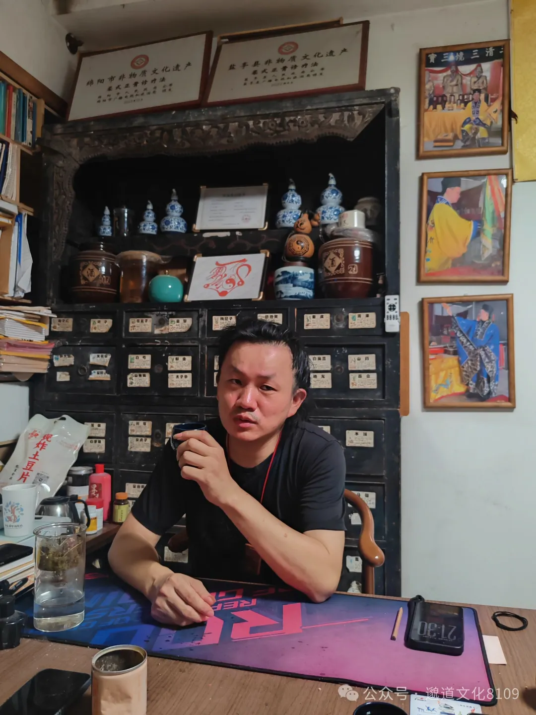 师父在药柜前品茶讲解