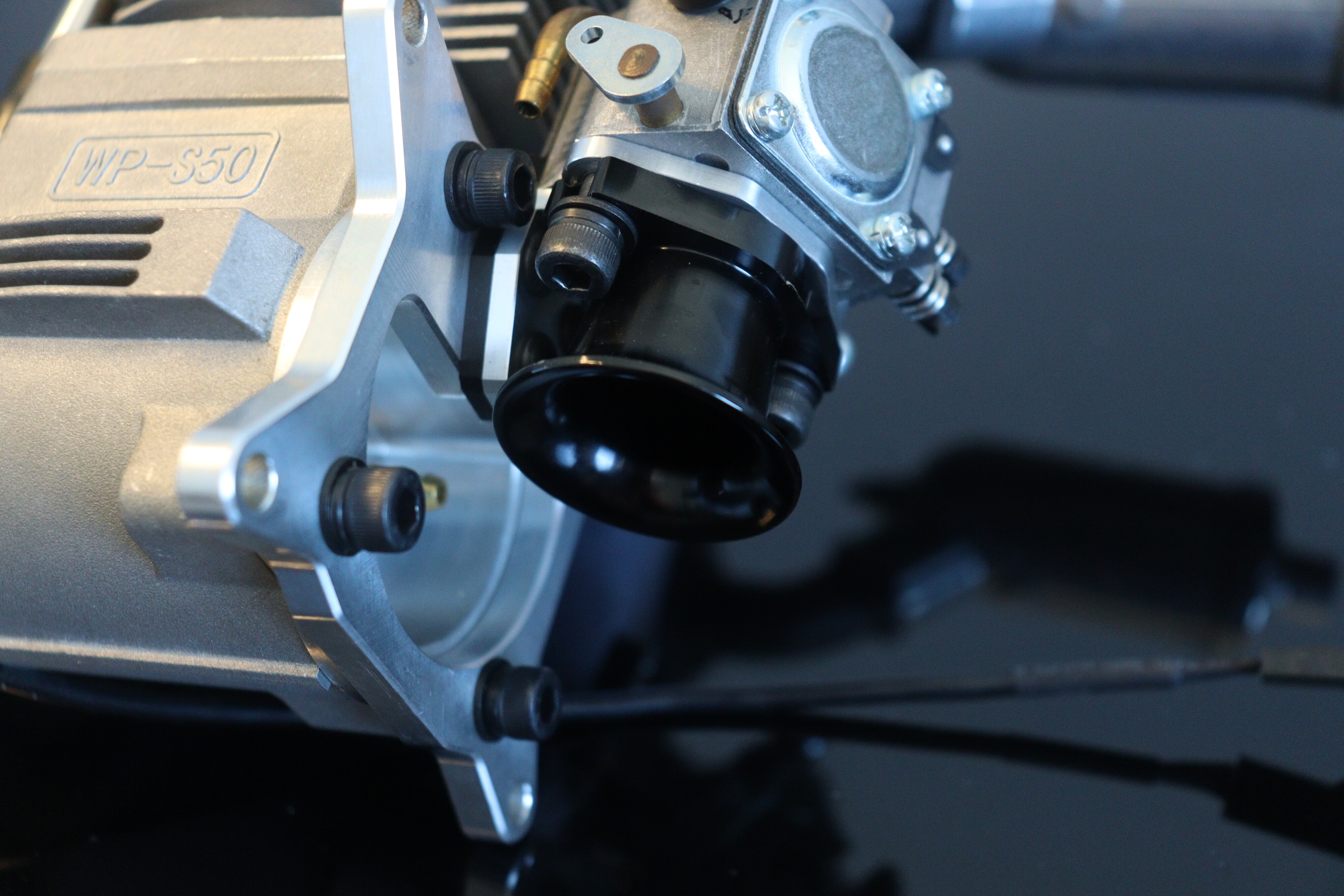 Close-up of carburetor and mounting bracket