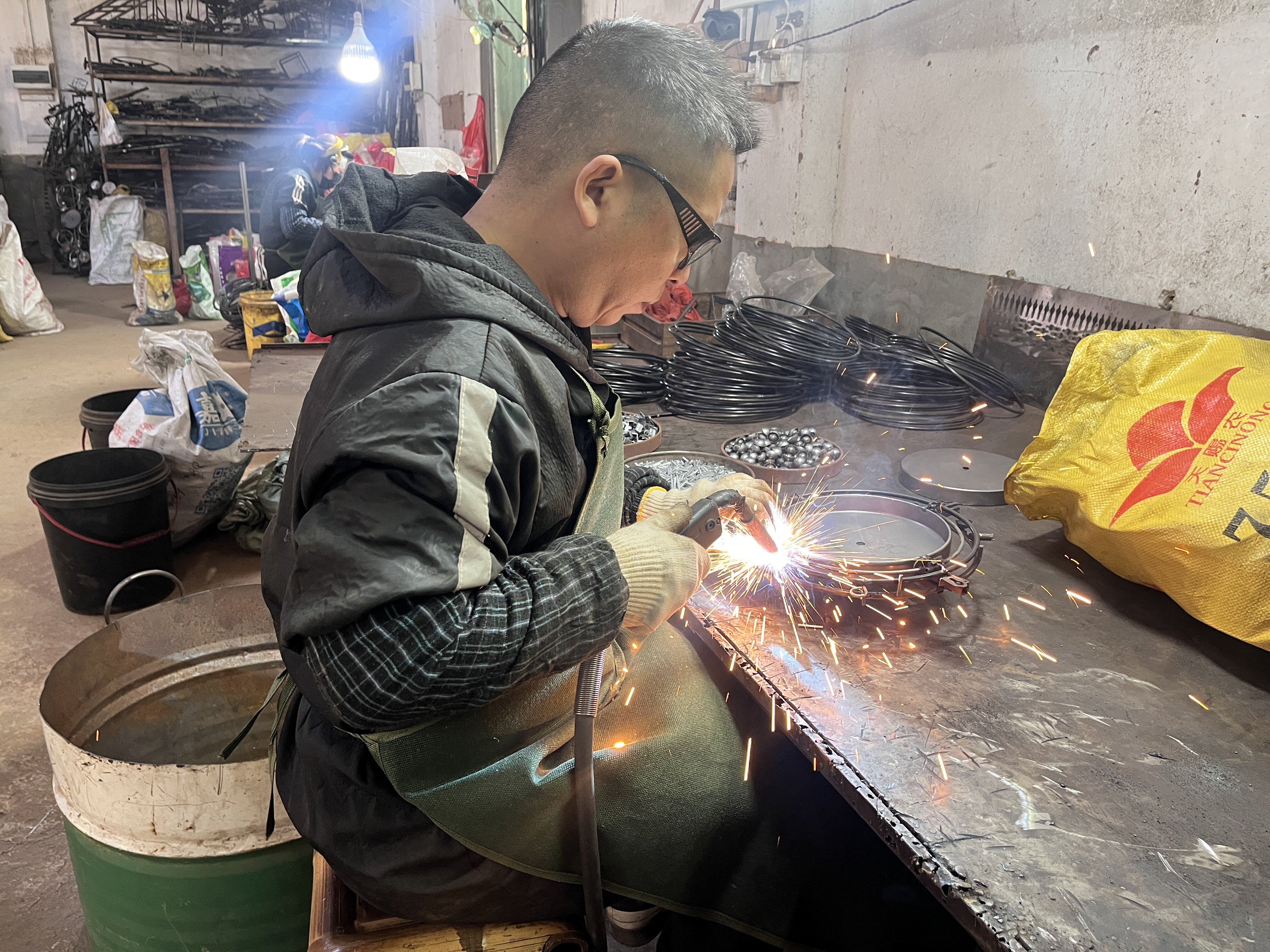 Artisan crafting iron and wood decorations in workshop